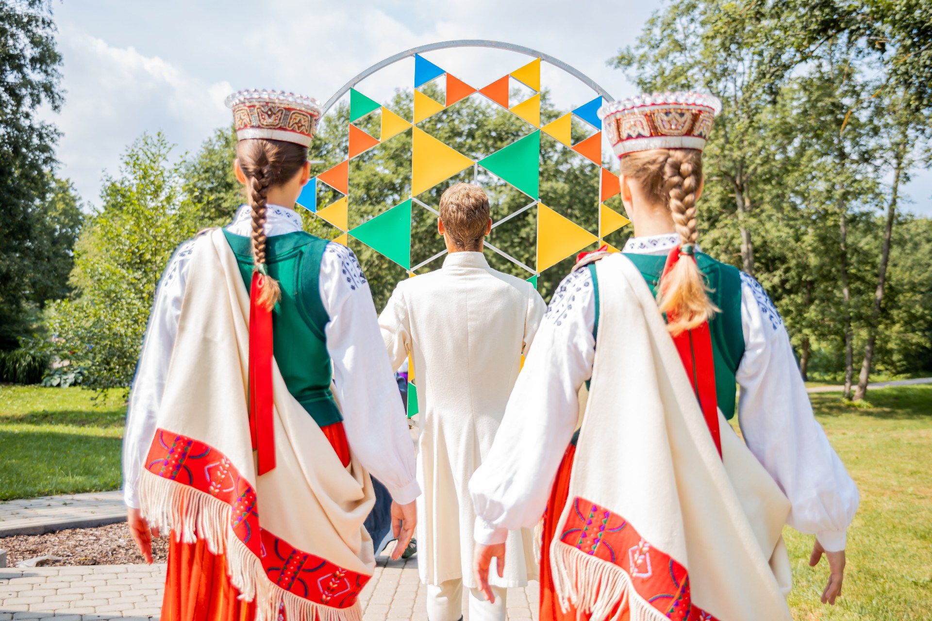 Młodzi ludzie w łotewskich strojach ludowych na Święcie Pieśni i Tańca